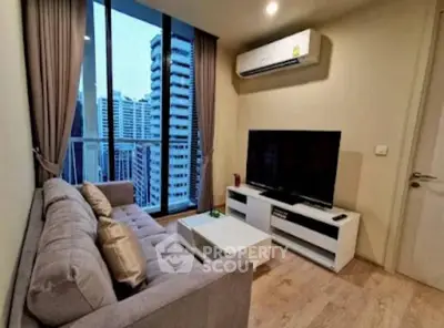Modern living room with city view, featuring a cozy sofa and large TV, perfect for urban living.