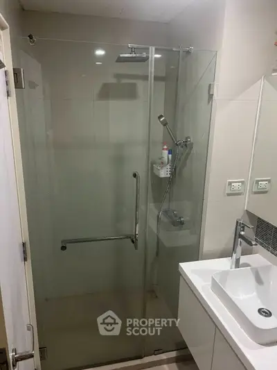 Modern bathroom with glass shower enclosure and sleek vanity