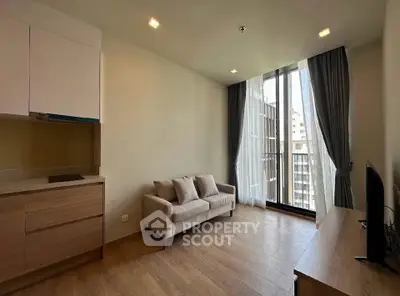 Modern living room with large windows and stylish furniture in a high-rise apartment.