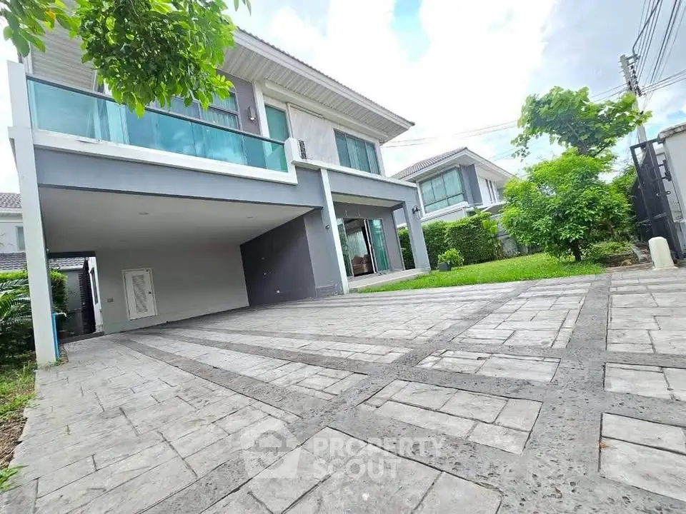 Modern two-story house with spacious driveway and lush greenery