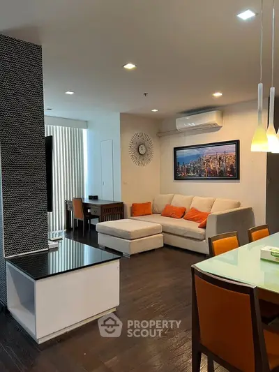 Modern living room with stylish decor, featuring a cozy sectional sofa and elegant dining area.