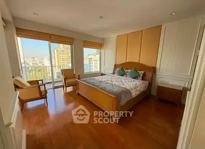 Spacious bedroom with wooden flooring and city view balcony in modern apartment