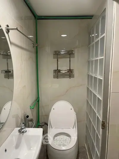 Compact modern bathroom with glass block wall and sleek fixtures