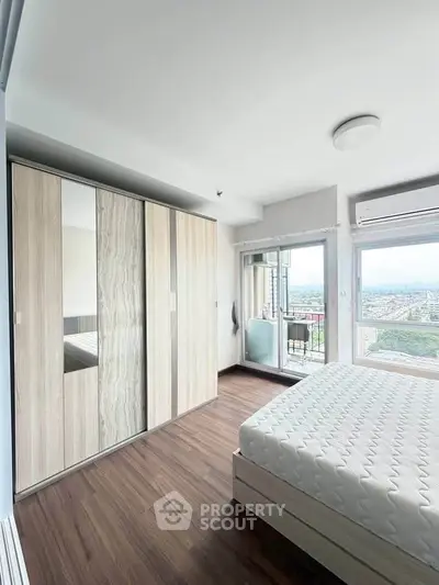 Modern bedroom with large wardrobe and balcony view, featuring sleek design and natural light.