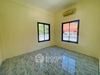 Bright empty room with tiled floor and air conditioning, ideal for customization.