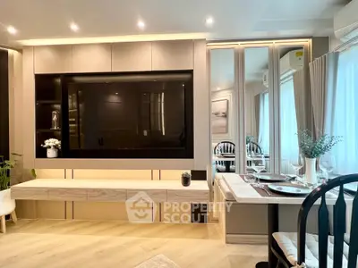 Modern living room with elegant decor and large TV, featuring stylish dining area and ambient lighting.