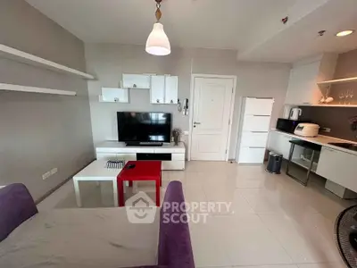 Modern living room with sleek kitchen, white cabinets, and cozy seating area in open layout apartment.