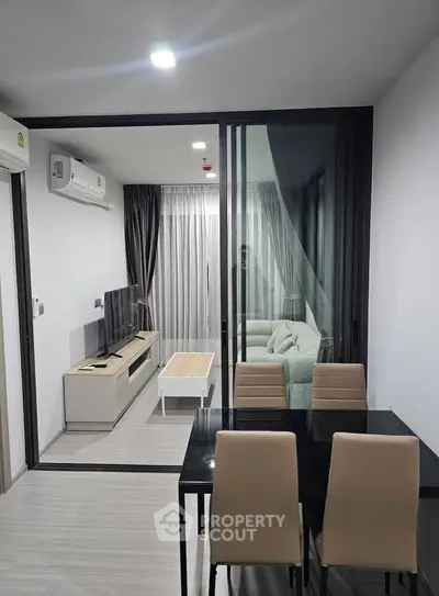 Modern living room with sleek furniture and glass partition in a stylish apartment.