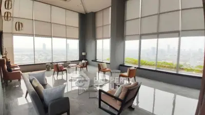 Spacious living room with panoramic city views and modern furniture.