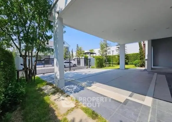 Spacious modern carport with sleek design and lush greenery in a serene residential area.