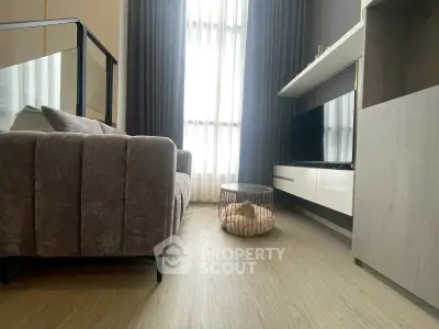 Modern living room with sleek furniture and large window, offering a cozy and inviting atmosphere.
