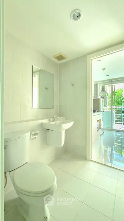 Bright modern bathroom with white tiles and natural light