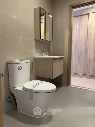 Modern bathroom with sleek fixtures and neutral tones, featuring a stylish vanity and mirror.