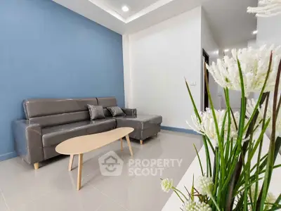 Modern living room with sleek gray sofa and stylish coffee table, accented by a vibrant blue feature wall.