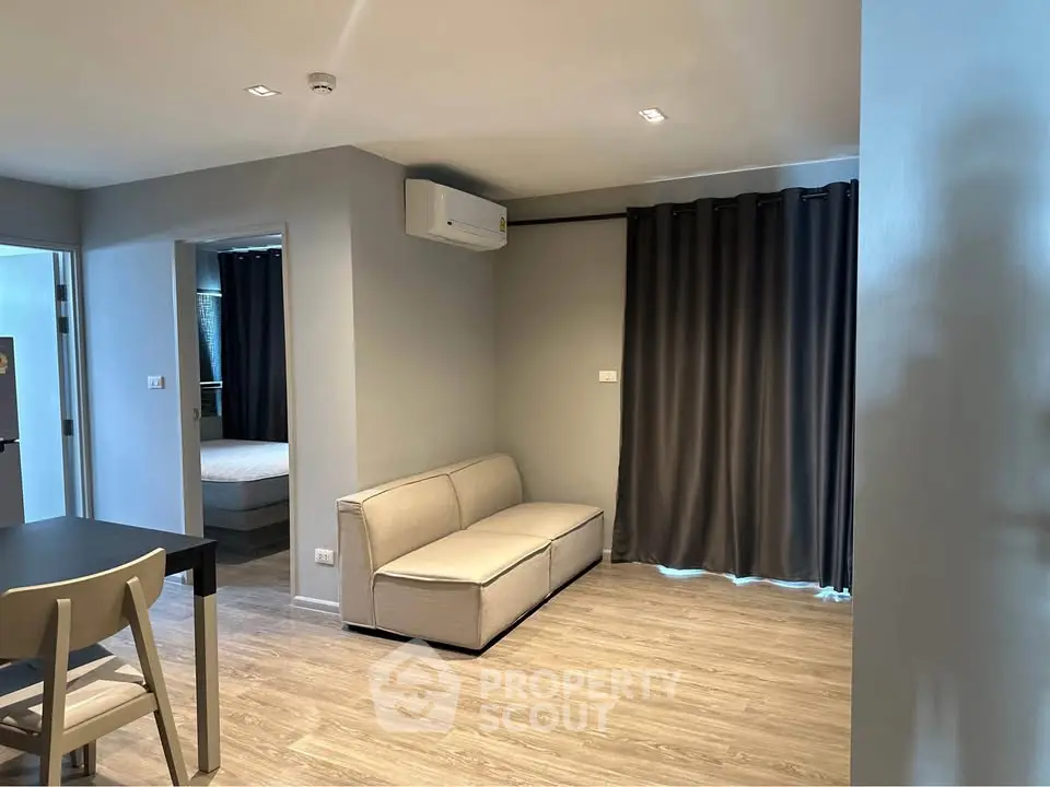 Modern living room with sleek furniture and wood flooring in a stylish apartment.