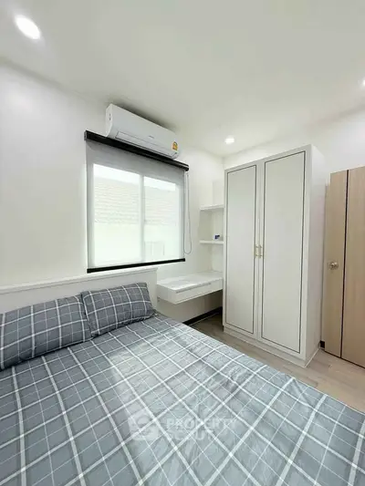 Bright bedroom with modern decor, featuring a cozy bed and ample storage space.