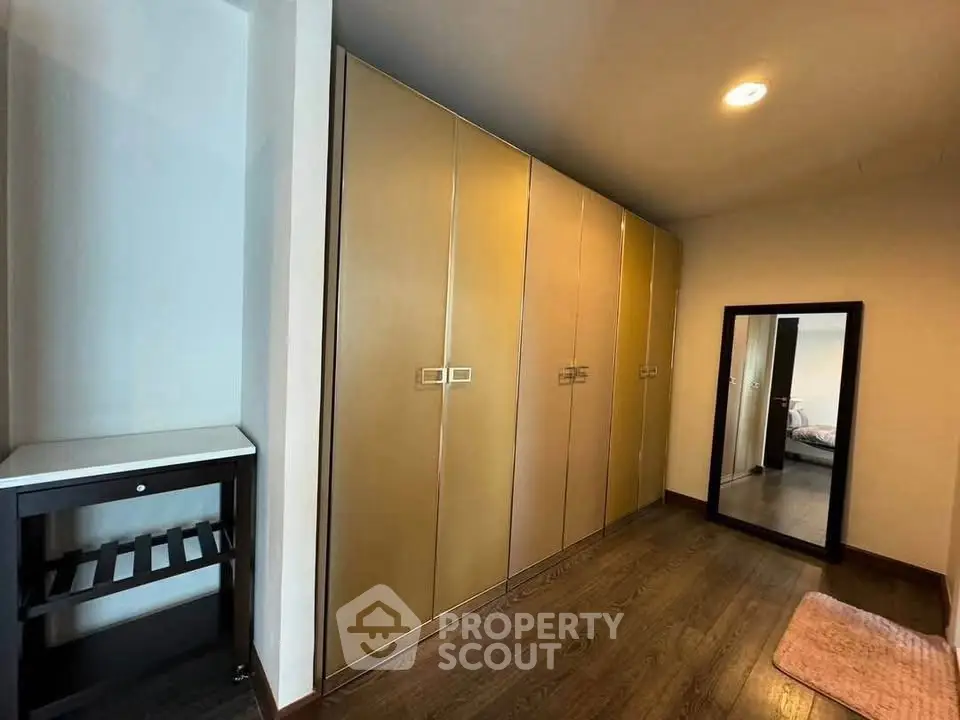 Spacious bedroom with ample closet space and elegant wooden flooring.