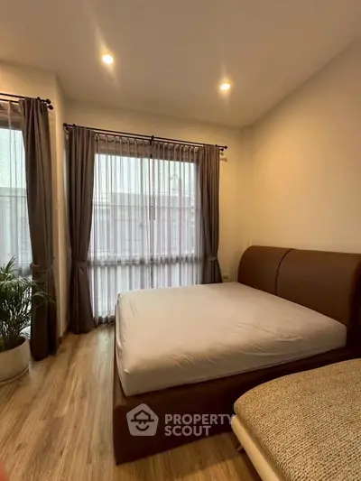 Cozy bedroom with modern decor and large windows for natural light