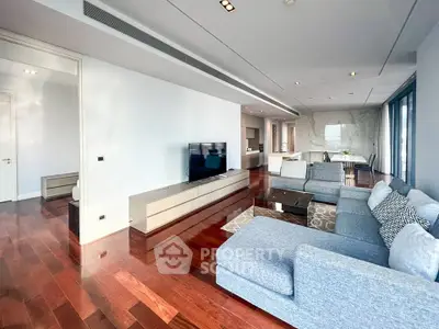 Spacious modern living room with sleek hardwood floors and stylish furniture in luxury apartment.