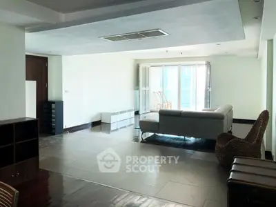 Spacious modern living room with large windows and stylish furniture in a high-rise apartment.