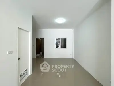 Spacious empty room with glossy tiled floor and white walls, ideal for customization.