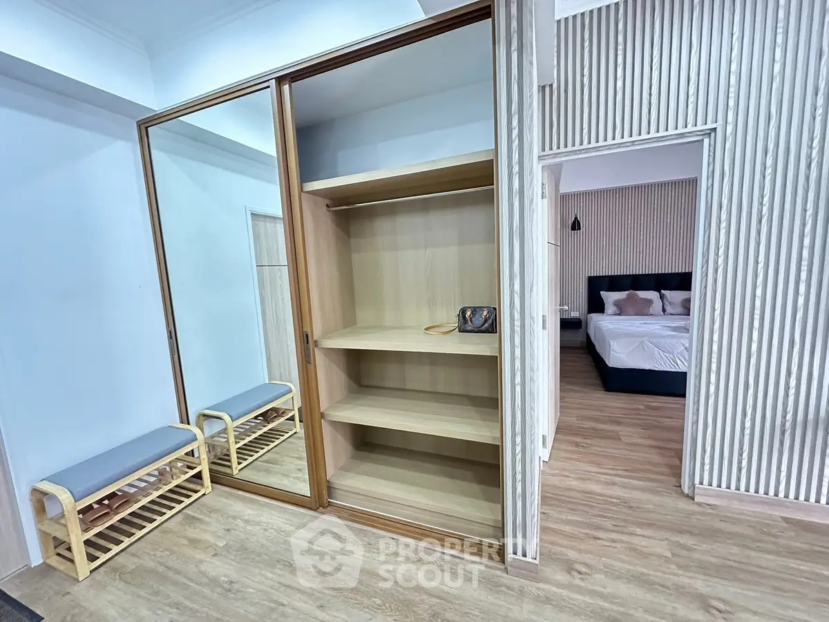 Spacious bedroom with wooden flooring and built-in wardrobe, perfect for modern living.