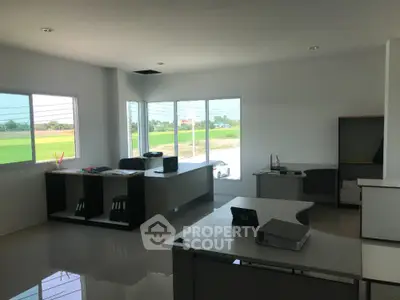 Modern office space with large windows and sleek furniture, offering a bright and productive work environment.