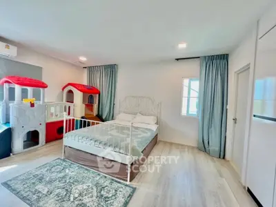 Spacious bedroom with play area, featuring a cozy bed and children's playhouses, ideal for family living.