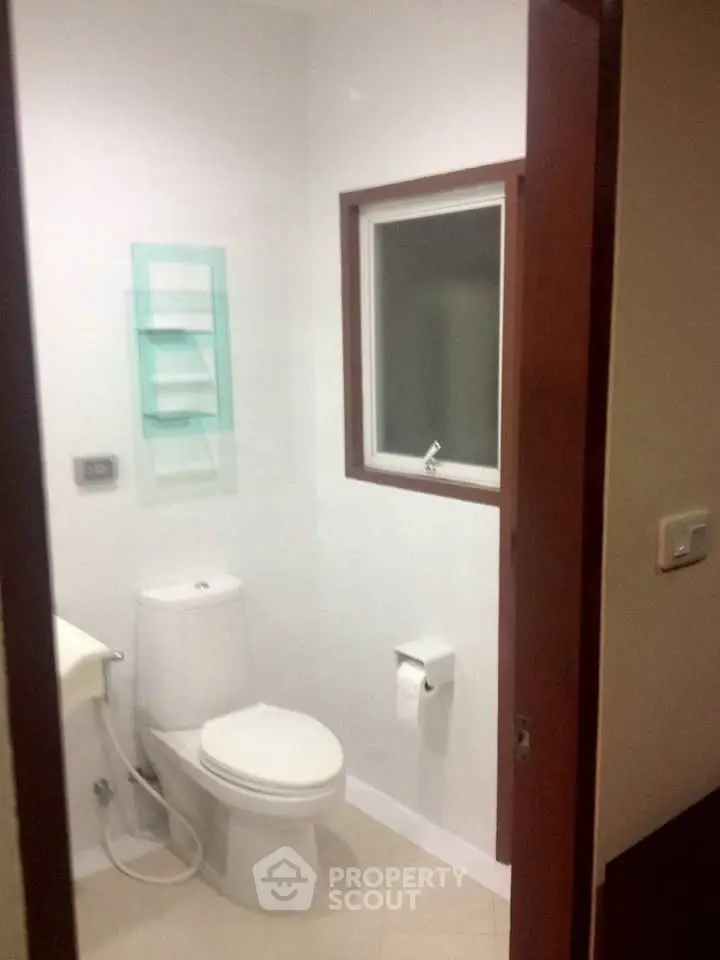 Compact bathroom with modern fixtures and window for natural light.
