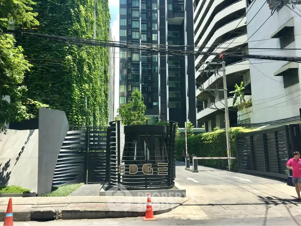 Modern building entrance with lush greenery and sleek design