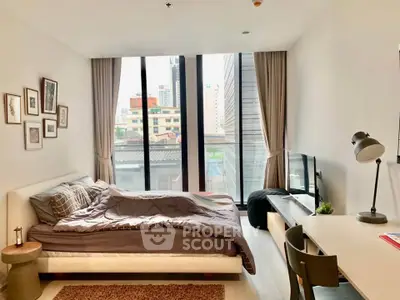 Modern bedroom with large windows and city view, featuring stylish decor and natural light.