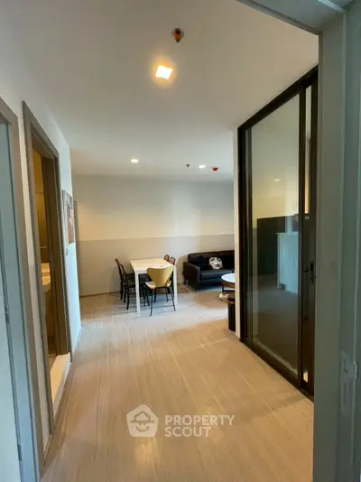 Modern apartment interior with dining and living area, featuring sleek design and ample natural light.