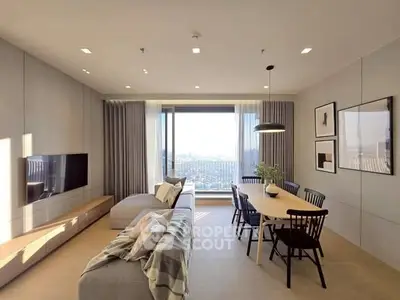 Spacious modern living room with large windows and elegant dining area, offering stunning city views.