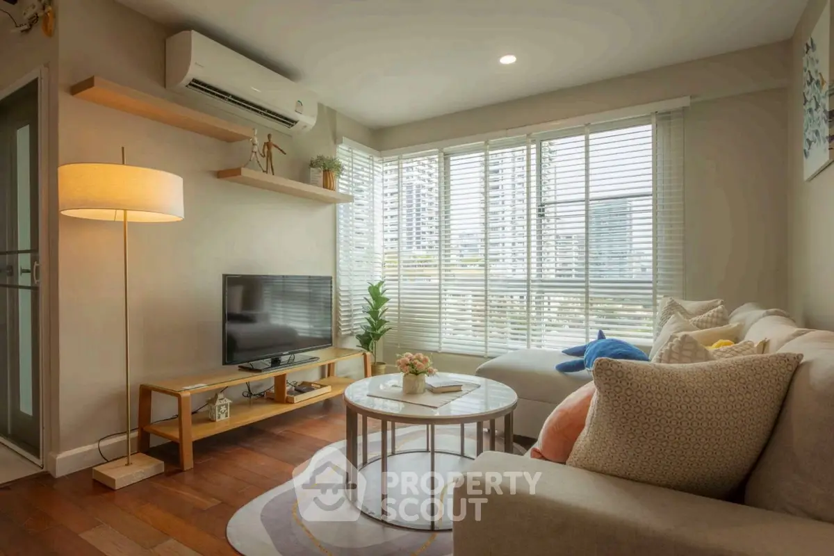 Cozy living room with modern decor and large windows offering natural light.