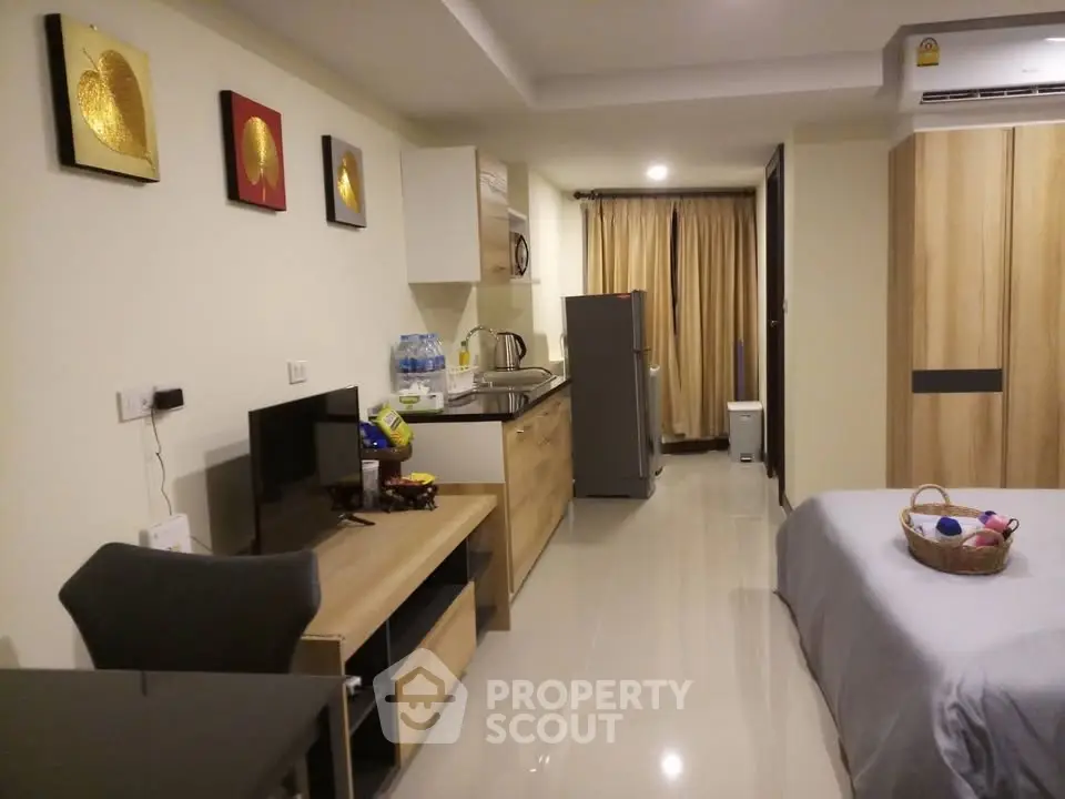 Modern studio apartment with open kitchen and cozy living area, featuring sleek furniture and stylish decor.