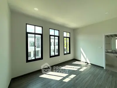 Bright and spacious room with large windows and modern flooring, perfect for a stylish home.