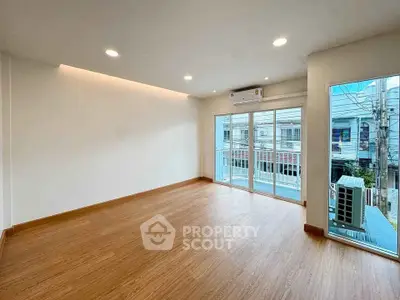 Spacious modern living room with large windows and wooden flooring
