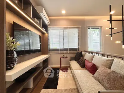 Modern living room with stylish decor, large TV, and cozy seating area, perfect for relaxation and entertainment.