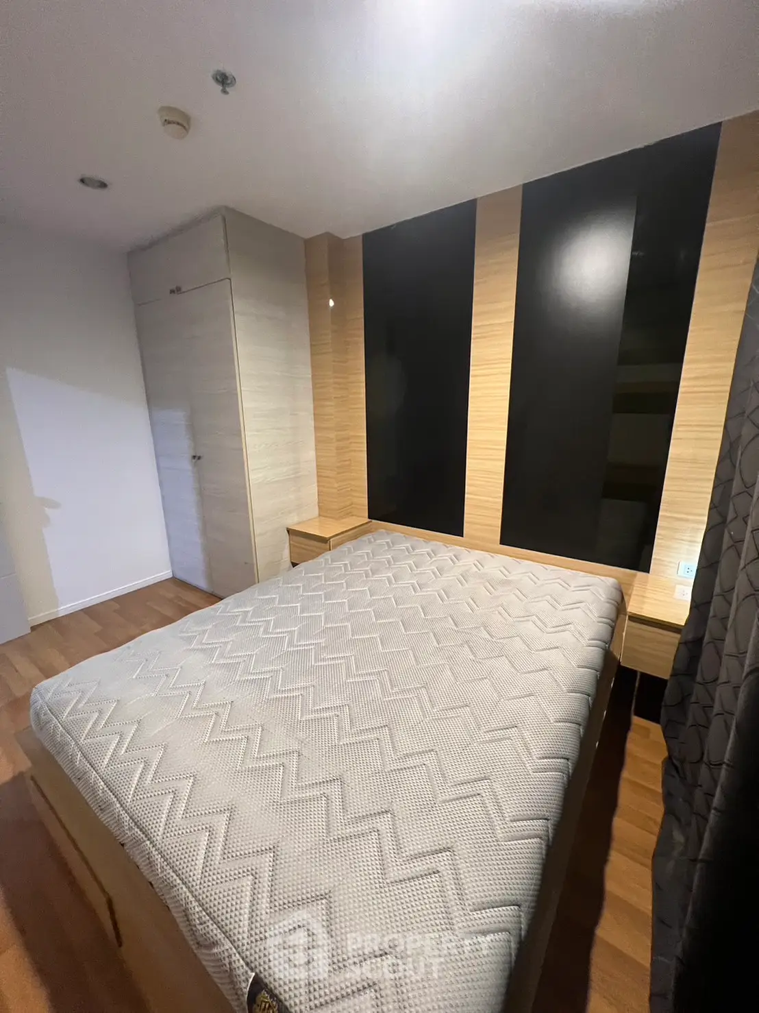 Modern bedroom with stylish wood paneling and cozy bed setup