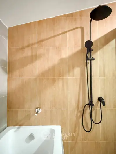 Modern bathroom with sleek shower and bathtub, featuring elegant tile design.