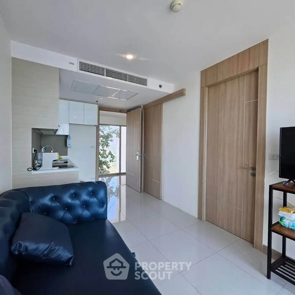 Modern living room with sleek design and open kitchen layout in a stylish apartment.