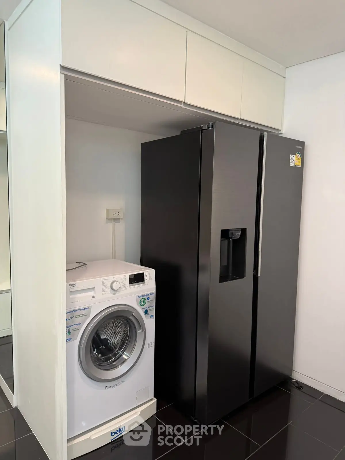 Modern kitchen with sleek black fridge and washing machine