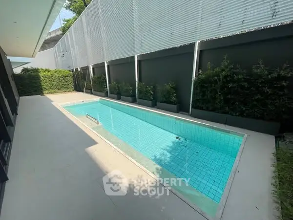 Luxurious private pool with modern design and lush greenery, perfect for relaxation and entertainment.