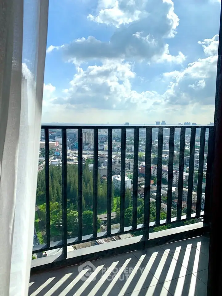 Stunning cityscape view from a high-rise balcony with clear blue skies.
