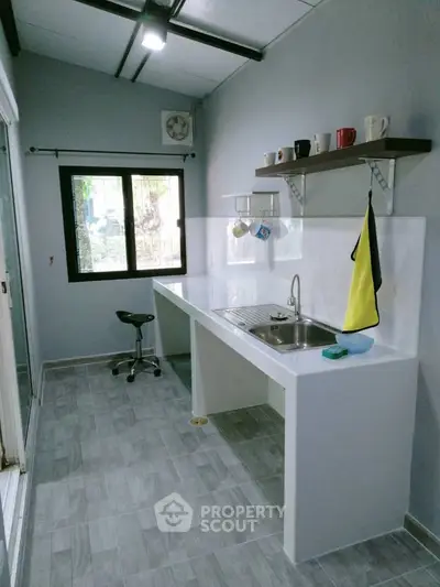 Modern kitchen with sleek design and open layout, featuring a large window and minimalist decor.