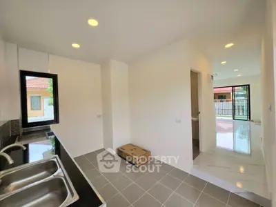 Modern kitchen with dual sinks and open layout leading to bright living area.