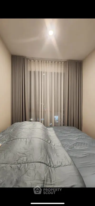 Cozy bedroom with elegant curtains and soft lighting, perfect for relaxation.