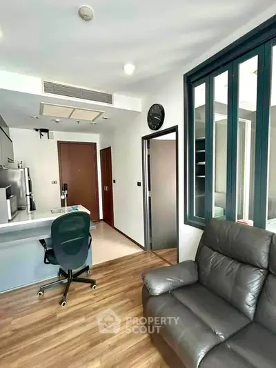 Modern living room with sleek furniture and open kitchen layout in a stylish apartment.