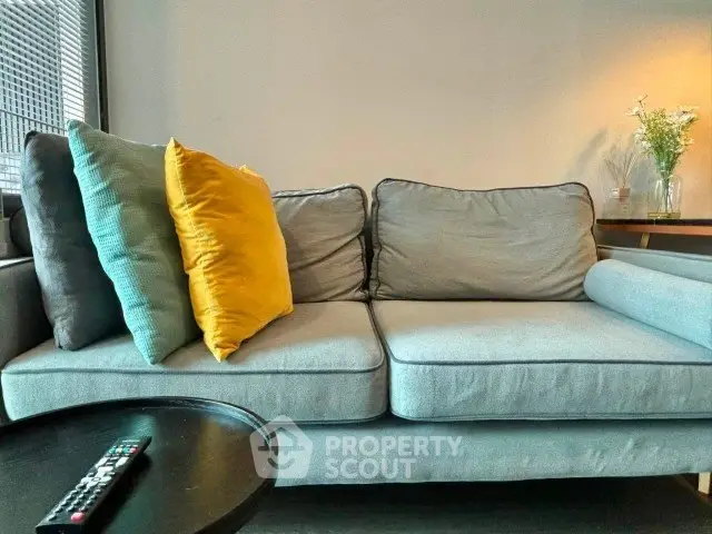 Modern living room with stylish gray sofa and colorful cushions, perfect for relaxation.