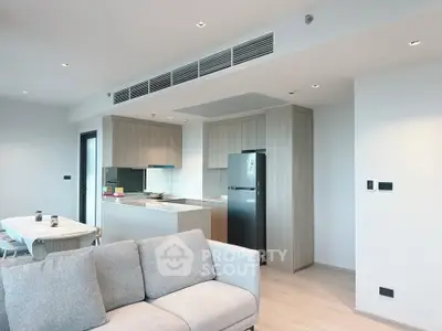 Modern open-plan living room and kitchen with sleek design and natural light